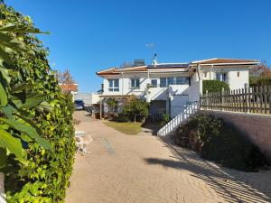 ein weißes Haus mit einem Zaun neben einer Straße in der Unterkunft Apartamento cerca del mar in Matalascañas