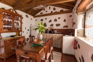 a kitchen with a wooden table in a room at Aldeia da Cuada in Faja Grande
