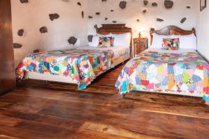 two beds in a room with wooden floors at Aldeia da Cuada in Faja Grande