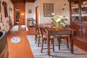 a dining room with a wooden table and chairs at Aldeia da Cuada in Faja Grande