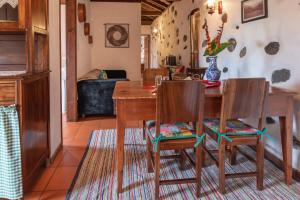 a dining room with a wooden table and chairs at Aldeia da Cuada in Faja Grande