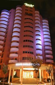 ブカレストにあるMonte Carlo Palace Suitesの紫色の照明が映える大きな建物