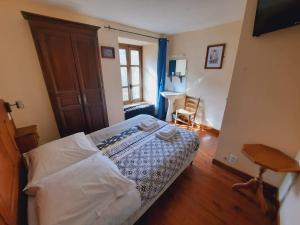 una camera con un letto in una stanza con una finestra di Hôtel des Voyageurs a Ferrières-Saint-Mary