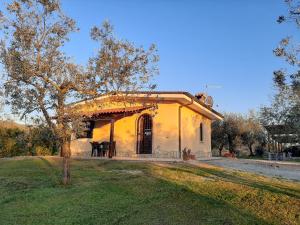 ein kleines gelbes Haus mit einem Baum davor in der Unterkunft Il Girasole B&B in Cretone