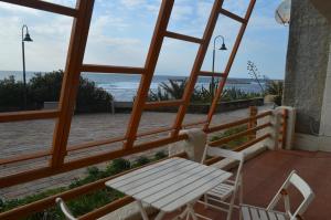 einen Tisch und Stühle auf einem Balkon mit Meerblick in der Unterkunft Casa del Giglio in S'archittu Cuglieri
