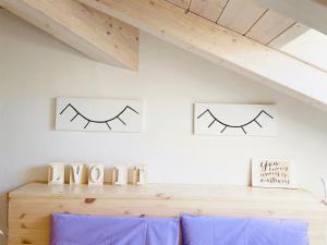a room with two pictures of eyebrows on the wall at Casa Lilla in Gravedona