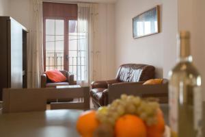 sala de estar con 2 sillas y mesa con naranjas en Apt Costa Dorada 1 by MarCalma, en Creixell