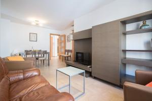 uma sala de estar com um sofá, uma televisão e uma mesa em Apt Costa Dorada 1 by MarCalma em Creixell