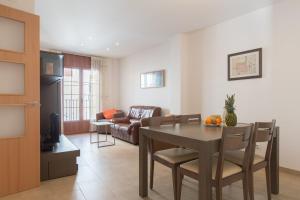 a dining room and living room with a table and chairs at Apt Costa Dorada 1 by MarCalma in Creixell