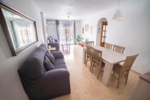 Sala de estar y comedor con sofá y mesa en Apartamento con piscina y terraza a 50 metros de la playa, en Roquetas de Mar