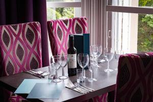 The Waverley Castle Hotel في ميلروز: طاولة مع كؤوس وزجاجة من النبيذ عليها