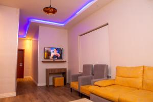 - un salon avec un canapé et une télévision dans l'établissement Riivana Tavern, à Lekki