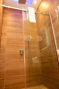 La salle de bains est pourvue d'une douche avec une porte en verre. dans l'établissement Riivana Tavern, à Lekki