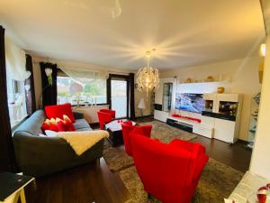 a living room with a couch and red chairs at Ferienhaus zur Waldauer Höhe mit 3 SZ, 120qm & 40qm Balkon in Schleusingen