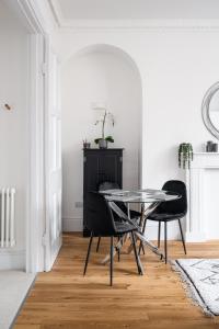 a dining room with a glass table and black chairs at River Street View in Bath