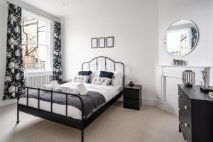 a bedroom with a black and white bed and a mirror at River Street View in Bath