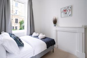 River Street View في باث: غرفة نوم بيضاء بها سرير ونافذة