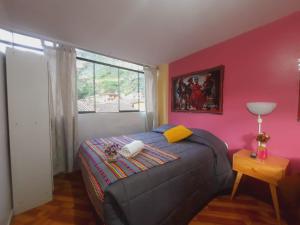 a bedroom with a bed and a window at Hostal Raymi in Ollantaytambo