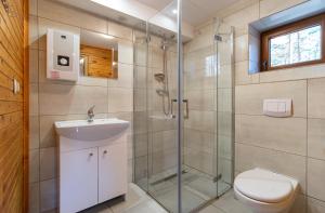 a bathroom with a shower and a toilet and a sink at Sława Family Resort in Lubiatów