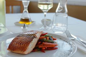 a white plate with a sandwich and vegetables on a table at Hotel Boutique Casa Werner in Puerto Varas