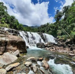 a waterfall in the jungle on a sunny day at Estalagem e Restaurante Cantinho Bistrô in Caparaó Velho