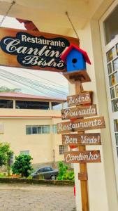 ein Schild für ein Restaurant vor einem Gebäude in der Unterkunft Estalagem e Restaurante Cantinho Bistrô in Caparaó Velho