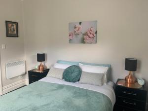 a bedroom with a bed and two night stands with lamps at Roslyn Business Studio - 2 bedroom in Dunedin