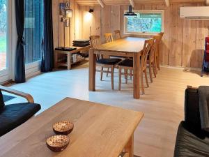 Oksbølにある6 person holiday home in Oksb lのリビングルーム(木製テーブル、椅子付)