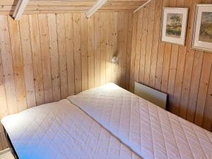 Oksbølにある6 person holiday home in Oksb lの木製の部屋にベッド1台が備わるベッドルーム1室があります。
