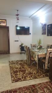 a dining room with a table and chairs and a tv at Beautiful Apartment Holiday in Casablanca