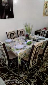 a dining room table with chairs and a tablecloth with plates at Beautiful Apartment Holiday in Casablanca