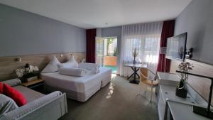 um quarto com uma grande cama branca e uma sala de estar em MATZ Brunnenhof em Wilgartswiesen