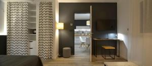a room with a bed and a desk and a kitchen at Apartments CityMap Maribor-Free parking! in Maribor