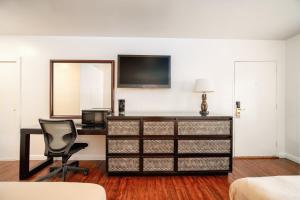 a room with a desk and a chair and a television at Hollywood Downtowner Inn in Los Angeles