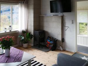 sala de estar con estufa de leña y mesa en 7 person holiday home in RSTA BRUNGOT, en Ørstavik
