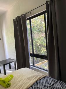 um quarto com uma cama e uma grande janela em MB rio em Jalpan de Serra
