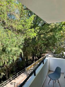 una silla se sienta en el balcón de una casa con árboles en MB rio, en Jalpan