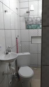 グアルーリョスにあるHOSTEL FAMÍLIA quartos privado próximo aeroporto Int Guarulhos SP TÁXI 24 hrsの白いトイレと洗面台のあるバスルーム