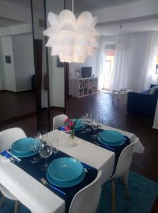 una mesa blanca con platos azules y vasos en ella en Céntrico apartamento de dos dormitorios, amplio y luminoso en Plasencia