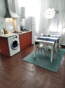 a kitchen with a dining table and a kitchen with a washing machine at Céntrico apartamento de dos dormitorios, amplio y luminoso in Plasencia