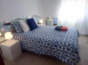a bedroom with a bed with a blue and white comforter at Céntrico apartamento de dos dormitorios, amplio y luminoso in Plasencia