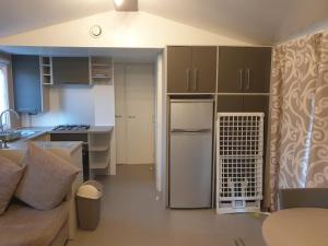 a kitchen and living room with a couch and a refrigerator at MobileHome **** Zoo-Beauval, Châteaux de la Loire in Onzain