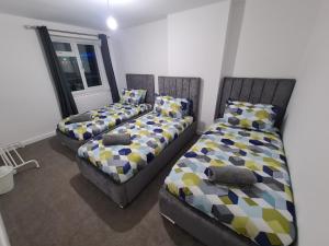 um quarto com 2 camas com almofadas e uma janela em 6 Bed sleeps 7, 1 mile from M54 i54 Jaguar Land Rover MOOG em Wolverhampton