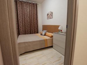 a small bedroom with a bed and a dresser at Villa Silvana-Fronte Mare in Marsala