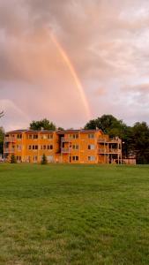 南海文的住宿－Lake Bluff Inn and Suites，一座橙色的建筑,天空中有一个彩虹