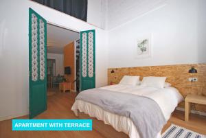 um quarto com uma cama grande e portas verdes em Apartments Valencia, Cabañal em Valência