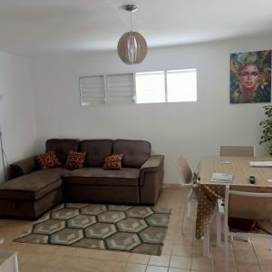 a living room with a couch and a table at Les Prunes vertes in Sainte-Rose