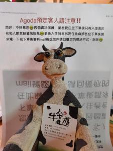 a stuffed giraffe with a sign on it at Cow House in Ji'an