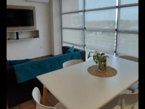 a white table and chairs in a room with a tv at Departamento Ezeiza in Ezeiza