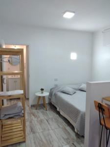 Schlafzimmer mit einem Bett, einem Tisch und einem Spiegel in der Unterkunft Moroty in Posadas